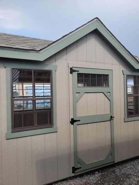 tan shed with green trim