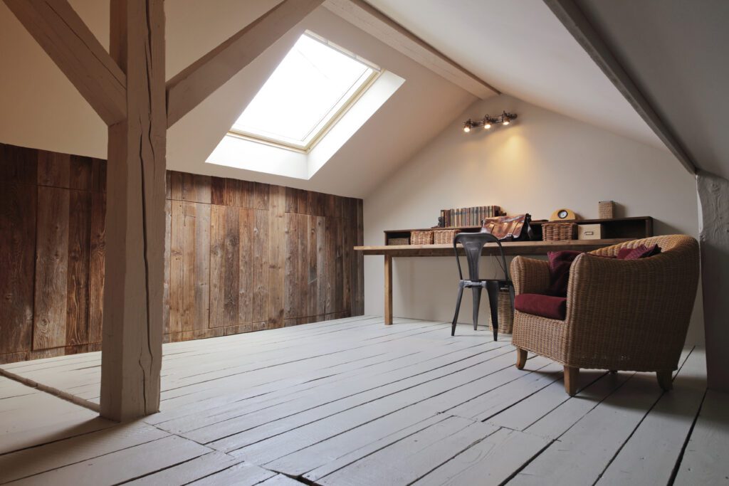A table and chairs in an attic space used as an office.