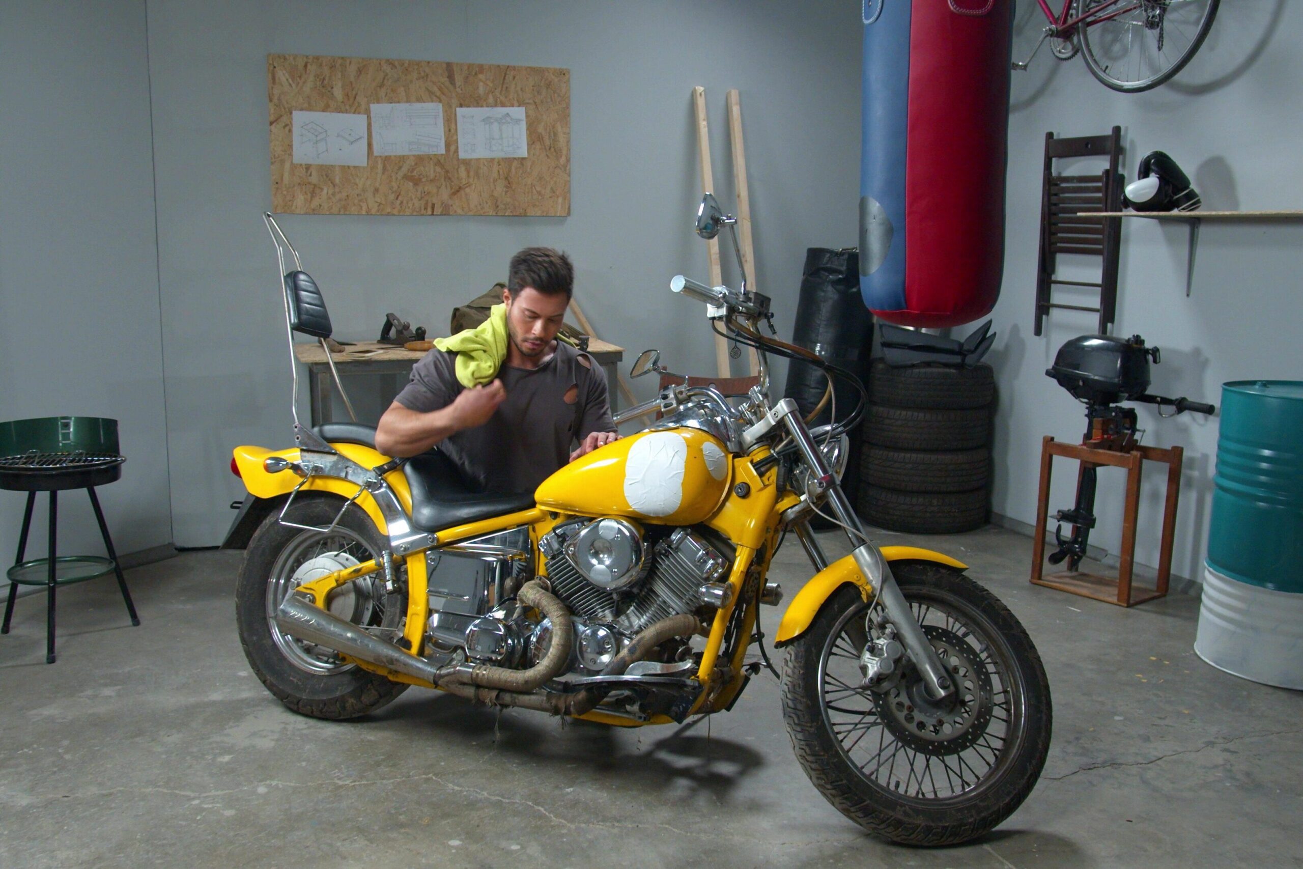 A man is working on a motorcycle inside a garage.