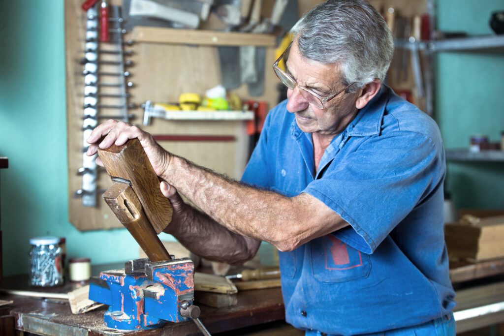 A man works on wood in his garage.